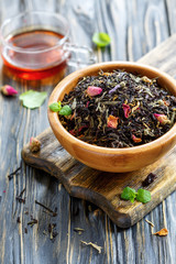 Bowl with black tea with flower petals and a cup of hot tea.