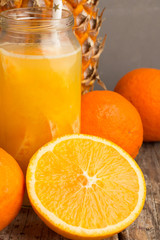 Naklejka na ściany i meble fruit juice, pineapple and oranges closeup.