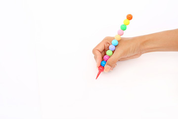 Hand holding colorful pencil on blank white paper background.