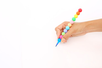 Hand holding colorful pencil on blank white paper background.