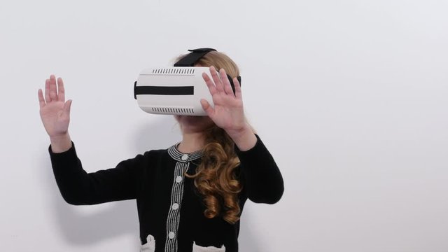 Young blonde girl playing game using VR-helmet for smart phones