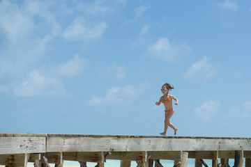 海の桟橋で遊ぶ女の子