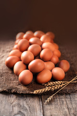 Heap of  eggs on dark wooden  background close up.