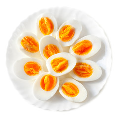 Boiled halved eggs on a; plate; isolated on white background