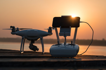 equipment for drive a drone with mobile phone and remote control on wooden surface with sunlight. - Powered by Adobe