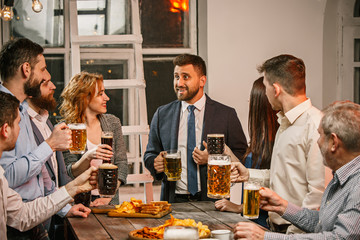 Group of friends enjoying evening drinks with beer