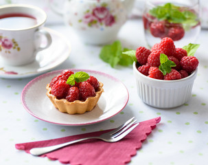 Cupcake with raspberries, mint on a table