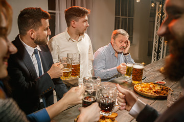 Group of friends enjoying evening drinks with beer