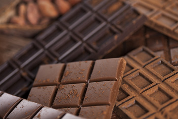 Dark homemade chocolate bars and cocoa pod on wooden