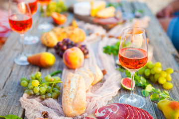 Picnic on the beach at sunset in boho style, food and drink concept