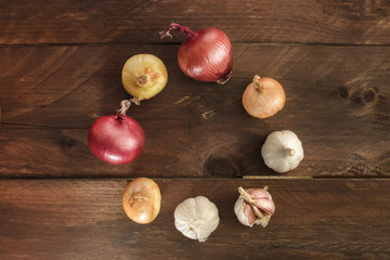 Garlic and onion bulbs on dark wooden background