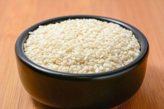 White sesame seeds in black bowl