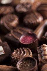 Chocolate bars and pralines on wooden background