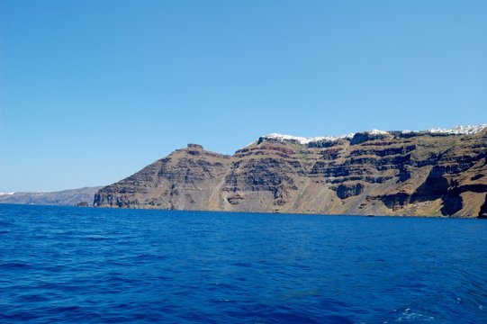 Scarce, waterless shore of the island of Santorini, Greece. Few people have adapted to live here. Sailing around the island by tour boat. From a trip to the Cycladic Archipelago