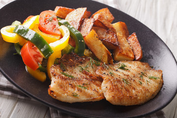 Grilled Tilapia fillet, fried potatoes, fresh salad close-up. horizontal