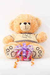 Brown teddy bear and gift boxes on a white background.