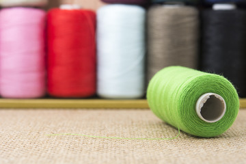 Green spools of thread on sackcloth
