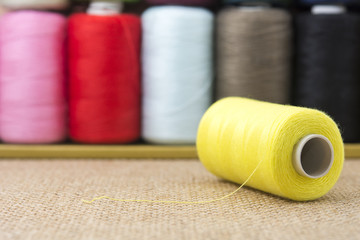 Yellow spools of thread on sackcloth