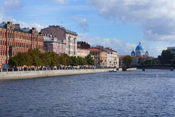 Obraz premium The granite embankment of the river, the house and the Cathedral on the other side