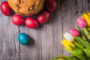 Easter eggs and tulips on wooden background