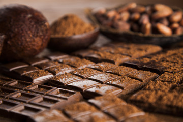 Dark homemade chocolate bars and cocoa pod on wooden