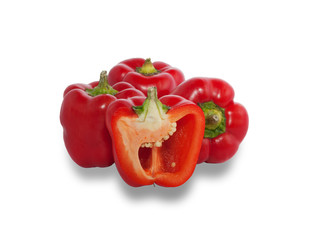 Several ripe red peppers, one of which is cut in half