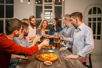 Group of friends enjoying evening drinks with beer