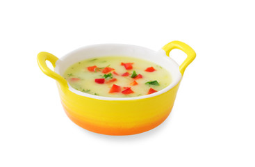 Vegetable soup with red pepper and herbs in a yellow tureen