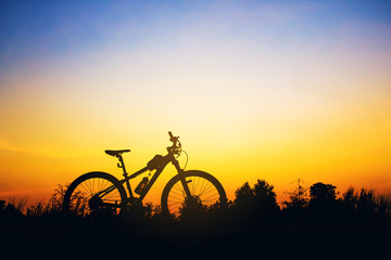 Fototapeta premium Silhouette Mountain biking at sunset. Photo Picture of a Mountai