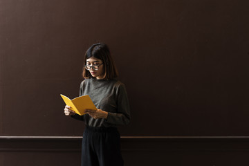 Girl with Glasses Standing Reading Book