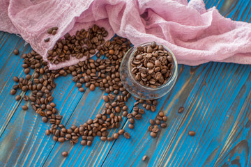Heart from the coffee beans on the blue wood background, to the day of Valentine