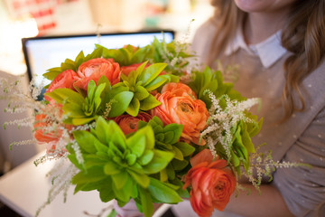 Flower delivery to the office. Young happy woman holding beautiful bouquet