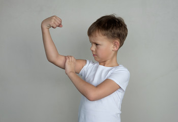 The boy checks the amount of biceps in the gym