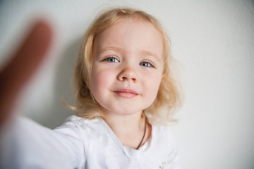 Fototapeta premium a beautiful little girl making a selfie