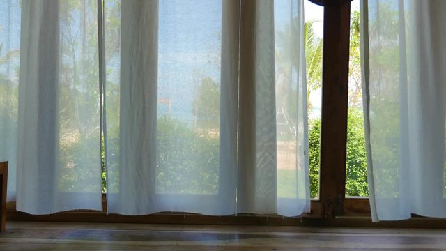 Beach view through white curtain