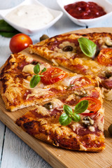Slices of pizza with bacon, olives and tomatoes
