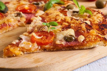 Slices of pizza with bacon, olives and tomatoes