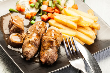 Pork rolls with french fries with vegetable