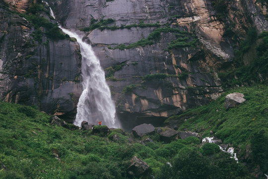Fototapeta Tiny traveler figure near the Yogini waterfall in Indian Himalaya