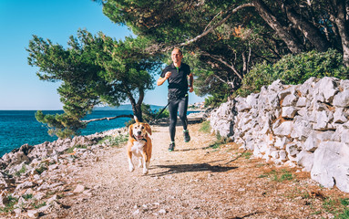 Man runs with dog near the sea