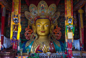 LEH, INDIA - MAY 9, 2015: Image of Lord Buddha in Thiksay Tibetan Buddhist monastery, located on top of a hill in Thiksey village, near Leh in Ladakh, India. Visitors reguraly come to pray here.