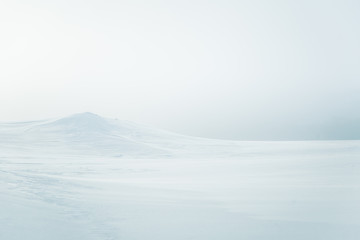 A beautiful, minimalist landscape of snowy Norwegian hills. Clean, light, high key, decorative look.