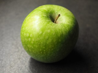 Green apple on grey ground