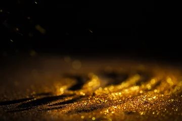 Foto op Plexiglas Licht en schaduw Strooi goudstof op een zwarte achtergrond met kopieerruimte