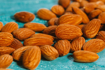 handful of almonds on a blue wooden background
