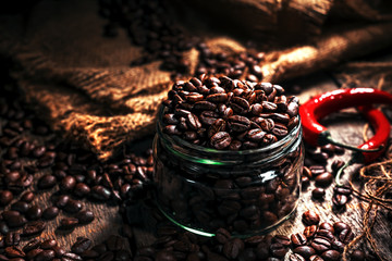 Coffee beans in a glass jar, black background
