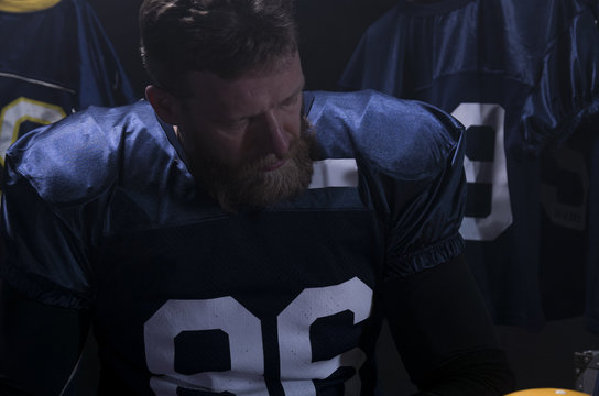 Portrait of Caucasian male American football player preparing for a game in a locker room