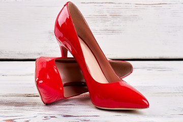 Red shoes on wooden background. Gift for lady.