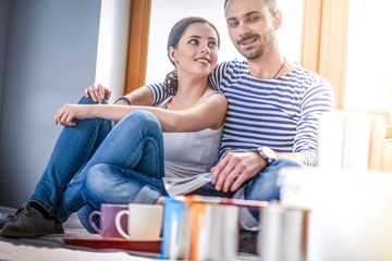 Couple moving in house sitting on the floor