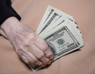 Old woman's hands holding dollars